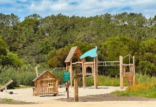Legeplads i træ omgivet af grønne træer i ferieparken Huttopia Lagoa de Óbidos i det centrale Portugal.