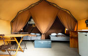 Interior view of a cozy safari tent with beds and amenities at Village Huttopia Lagoa de Óbidos, Portugal.