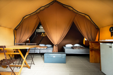 Binnenzicht van een gezellige safaritent met bedden en voorzieningen bij Village Huttopia Lagoa de Óbidos.