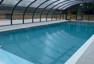Indendørs swimmingpool under glastag på Camping Seasonova du Chêne, feriested i Pays de la Loire, Frankrig.