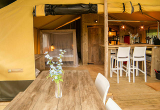 Interieur van de Safari lodge tent op Camping Kost Ar Moor in Frankrijk met houten meubels en gezellige sfeer.