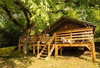 Safari Lodge + Teeny Lodge: Tienda safari elevada sobre plataforma de madera con hamaca, en entornos naturales verdes.