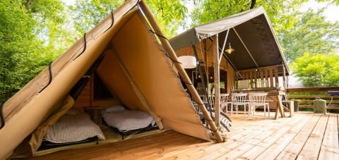 Safari Lodge and Teeny Lodge tents on a wooden deck surrounded by greenery at Camping Les Tailladis, France.