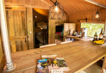 Binnenzicht van de Safari Lodge + Teeny Lodge tent bij Camping Les Tailladis in Frankrijk, met houten inrichting.