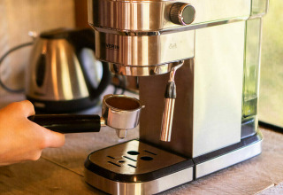 Una persona prepara il caffè con una macchina per espresso in una tenda safari al Camping Les Tailladis, Francia.