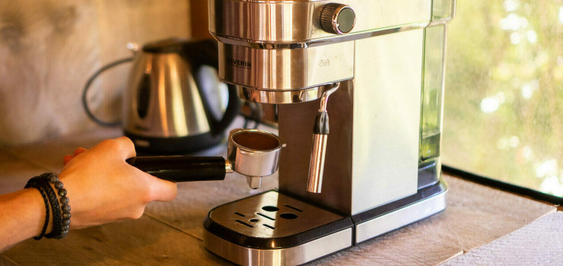 Una persona prepara café con una cafetera espresso en una tienda safari en Camping Les Tailladis, Francia.