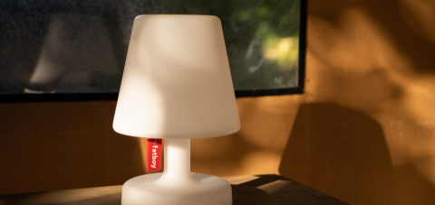 Bordlampe med mærkat 'fatboy' på et bord inde i en safaritelte i Safari Lodge, Camping Les Tailladis, Frankrig.