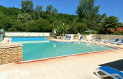 Piscina exterior con tumbonas y entorno natural en Camping Les Tailladis, Nouvelle-Aquitaine, Francia.
