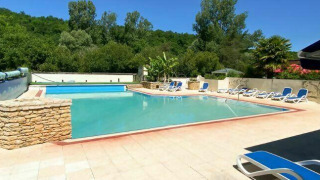 Piscina exterior con tumbonas y entorno natural en Camping Les Tailladis, Nouvelle-Aquitaine, Francia.
