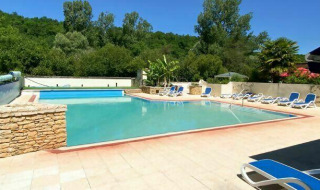 Piscina exterior con tumbonas y entorno natural en Camping Les Tailladis, Nouvelle-Aquitaine, Francia.