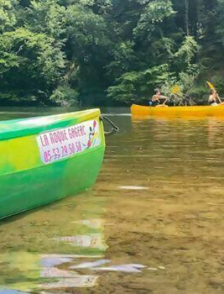 Paseo en canoa en Camping Les Tailladis, Nouvelle-Aquitaine, Francia, entre un río claro y naturaleza verde.