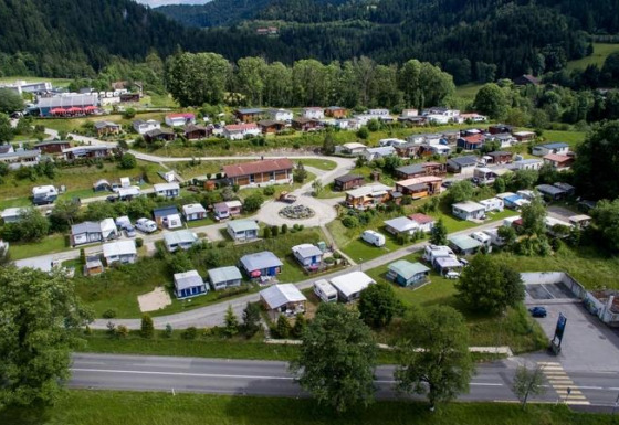Vista aerea di Camping Lac des Brenets, un villaggio vacanze a Neuchâtel, Svizzera, con roulotte e verde.