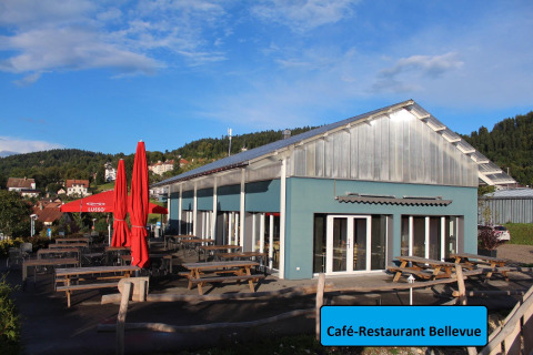 Café-Restaurant Bellevue bij Camping Lac des Brenets, Neuchâtel, met terras en uitzicht op heuvels.