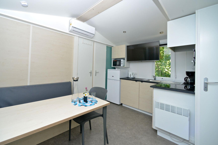 Cocina y comedor modernos en mobile home en Drau Camping Sachsenburg, Austria, con TV y aire acondicionado.