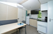 Cocina y comedor modernos en mobile home en Drau Camping Sachsenburg, Austria, con TV y aire acondicionado.