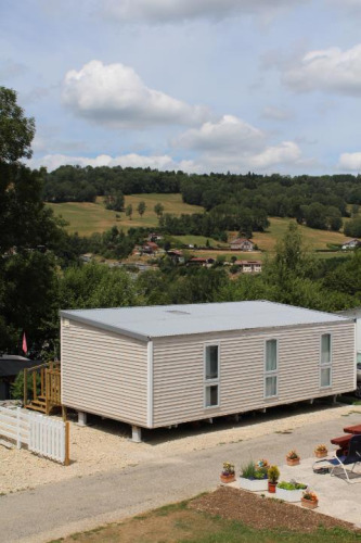 Mobile home O'Hara at Camping Lac des Brenets in Switzerland, surrounded by hills and countryside views.