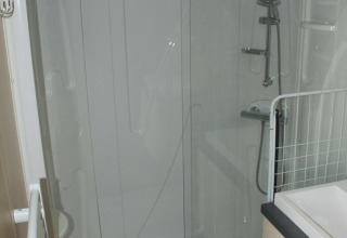 Shower area with glass door in the bathroom of Mobile home O'Hara at Camping Lac des Brenets, Switzerland.