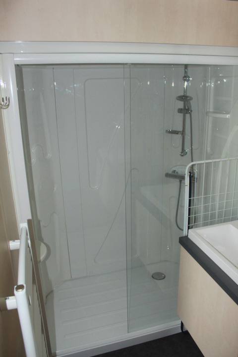 Douche avec porte en verre dans la salle de bain du Mobile home O'Hara au Camping Lac des Brenets, Suisse.