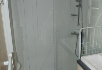 Douchecabine met glazen deur in de badkamer van Mobile home O'Hara op Camping Lac des Brenets, Zwitserland.