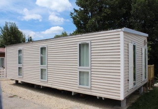 Mobilhome O'Hara på Camping Lac des Brenets i Schweiz, viser udvendig lyse facade og vinduer.