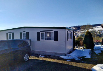 Das Lavandou Mobilheim auf dem Campingplatz Lac des Brenets in der Schweiz, umgeben von Schnee.