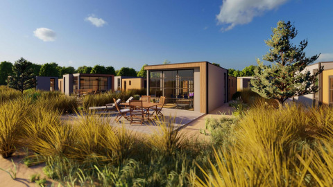Buitenaanzicht van de Cube Exclusif lodge met modern design, terrasstoelen en natuurlijke begroeiing.