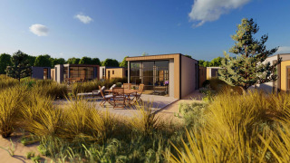 Buitenbeeld van Cube Exclusif lodge met modern ontwerp, zitje op terras en groene beplanting rondom.