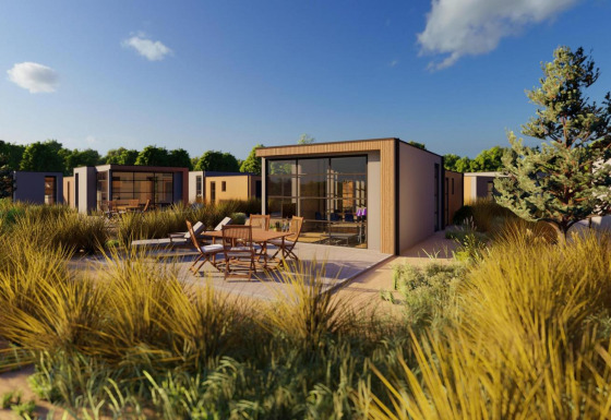 Buitenaanzicht van de Cube Exclusif lodge met modern design, terrasstoelen en natuurlijke begroeiing.