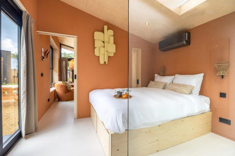 Modernes, kleines Schlafzimmer in der Tiny Wellness Suite im Ferienpark De IJsvogel, Niederlande, mit hellem Holz.