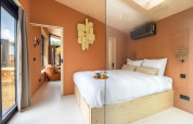 Modern tiny house bedroom in the Tiny Wellness Suite at Holiday Park De IJsvogel, Netherlands, stylishly furnished.