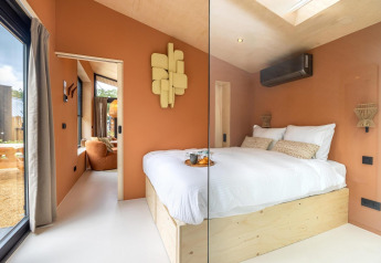 Dormitorio moderno en miniatura de la Tiny Wellness Suite en Holiday Park De IJsvogel, Países Bajos, decoración cálida.