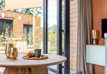 Intérieur chaleureux de la Tiny Wellness Suite au Holiday Park De IJsvogel, vue sur le jardin, Pays-Bas.