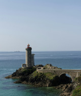 Vista paisajística de un faro sobre una costa rocosa cerca de Trélévern, Bretaña, Francia, en un día despejado.