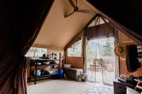 Binnenaanzicht van een luxe tent in Village Huttopia Lagoa de Óbidos, met terras en kampeerspullen.