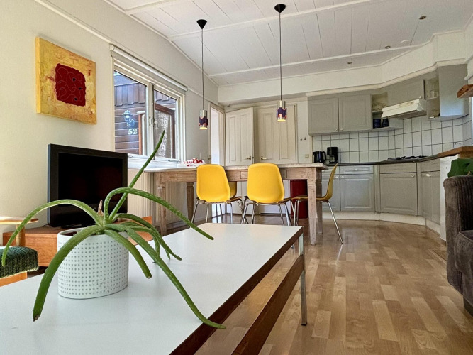 Acogedora cocina y sala retro en Retro Lodge, Bungalowpark Het Verscholen Dorp, Países Bajos, con sillas amarillas.