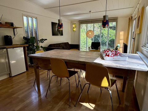 Woon- en eetgedeelte van Retro Lodge in Bungalowpark Het Verscholen Dorp, Nederland, met modern interieur.