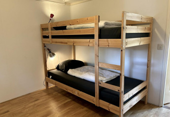 Camera con letto a castello in legno e due lampade da lettura al Retro Lodge, Bungalowpark Het Verscholen Dorp, Paesi Bassi.