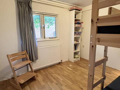 Kamer in Retro Lodge bij Bungalowpark Het Verscholen Dorp, Nederland, met stapelbed en boekenkast.