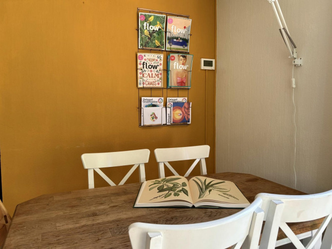 Acogedor rincón en Tiny Lodge Basic, Bungalowpark Het Verscholen Dorp, con sillas y revistas en la pared.