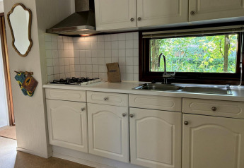 Cucina del Tiny Lodge Basic al Bungalowpark Het Verscholen Dorp nei Paesi Bassi, vista finestra verde.