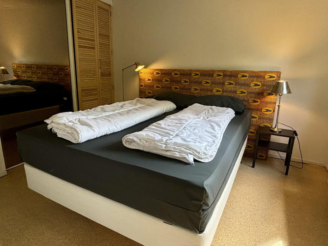 Dormitorio en Tiny Lodge Basic, Bungalowpark Het Verscholen Dorp, Países Bajos, con cama doble y lámparas.