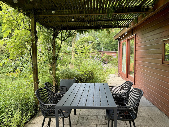 Patio exterior de Tiny Lodge Basic en Bungalowpark Het Verscholen Dorp, Países Bajos, con mesa y sillas.