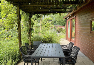 Patio exterior de Tiny Lodge Basic en Bungalowpark Het Verscholen Dorp, Países Bajos, con mesa y sillas.