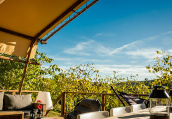 View from the Desert Lodge safari tent with private bathroom at Camping Pian di Boccio, Italy, on a sunny day.