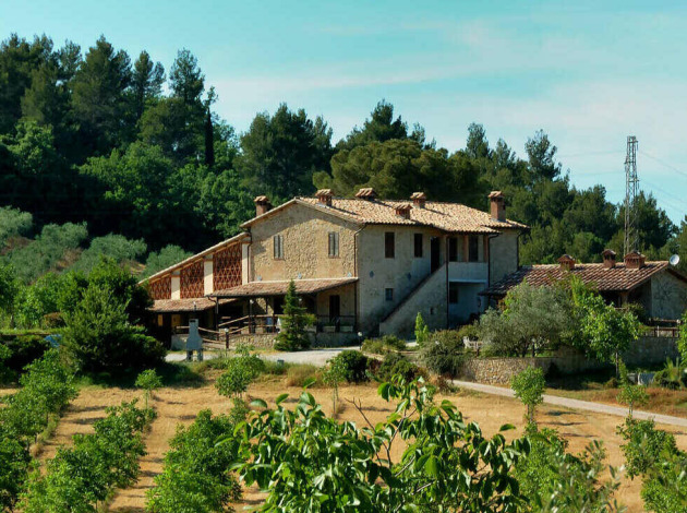 Grote boerderij in het groen bij Camping Pian di Boccio, een vakantiepark in Umbrië, Italië.