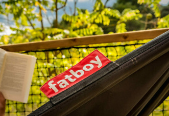 Persoon leest een boek in een zwarte Fatboy-hangmat bij Safari Lodge op Camping Pian di Boccio in Italië.