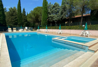 Piscina all'aperto con lettini e ombrelloni presso Camping Pian di Boccio in Umbria, Italia.