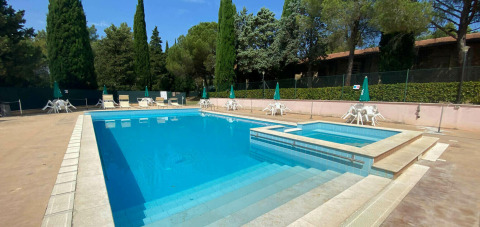 Udendørs swimmingpool med afslapningsområde og liggestole på Camping Pian di Boccio i Umbrien, Italien.
