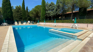 Piscina al aire libre con tumbonas y sombrillas en Camping Pian di Boccio en Umbría, Italia.