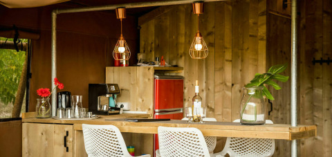 Accogliente cucina nella tenda safari Desert Lodge al Camping Pian di Boccio, Italia, con arredi in legno moderni.